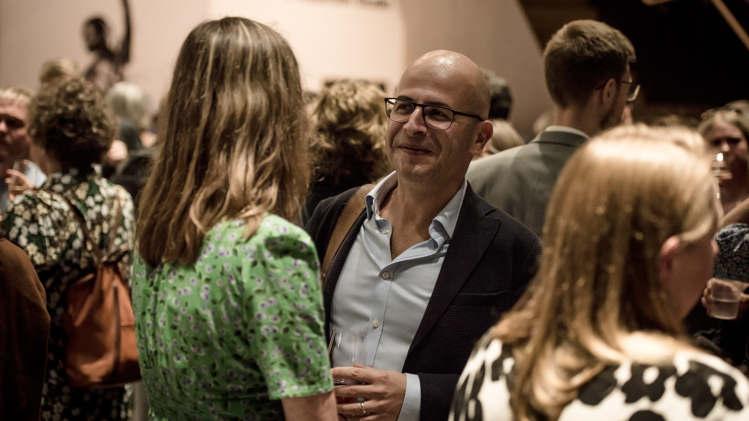 A woman talking to a man at an interval reception at an OAE event